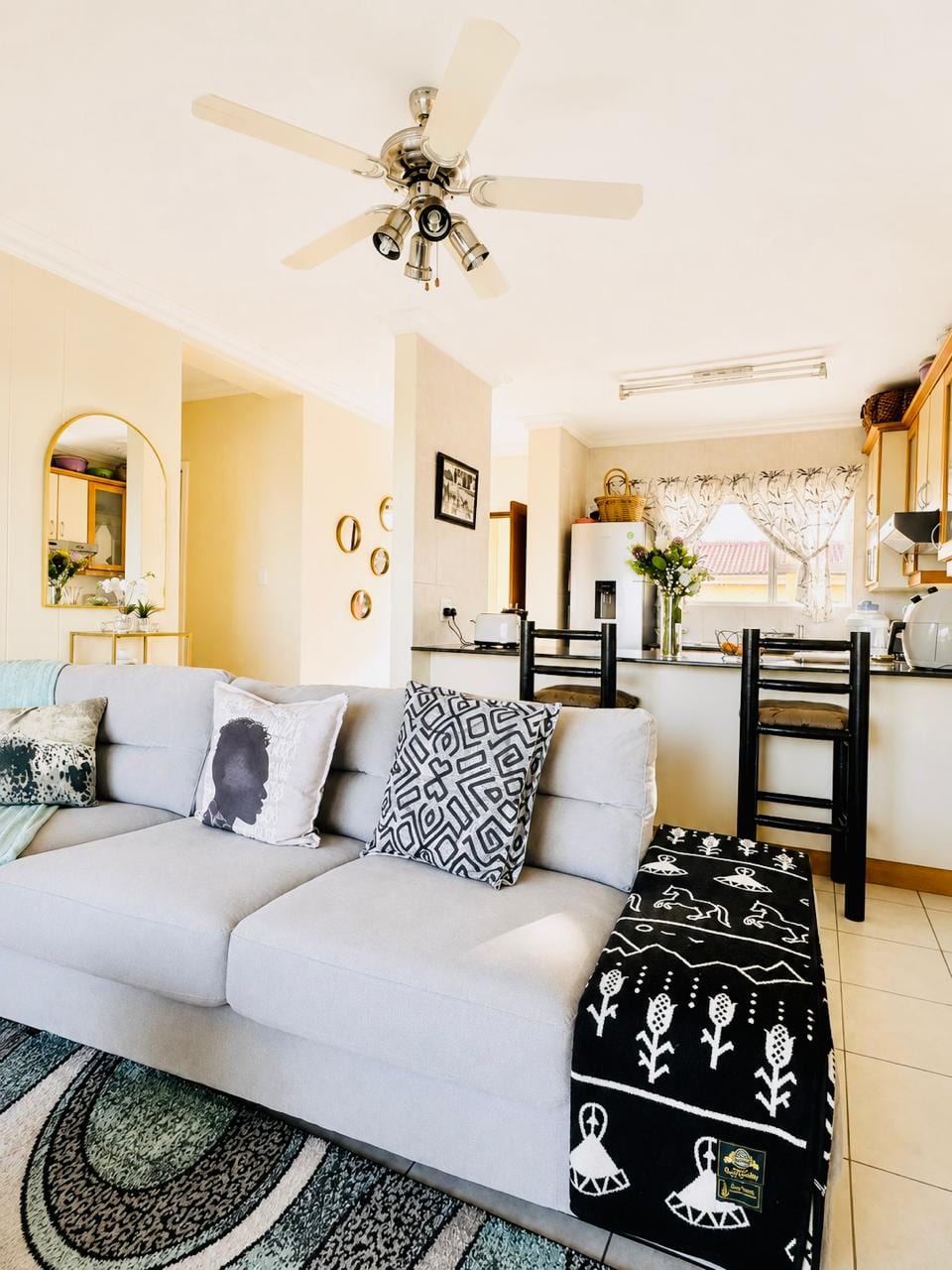 Open-plan living and dining beneath the ceiling fan, looking through to the kitchen