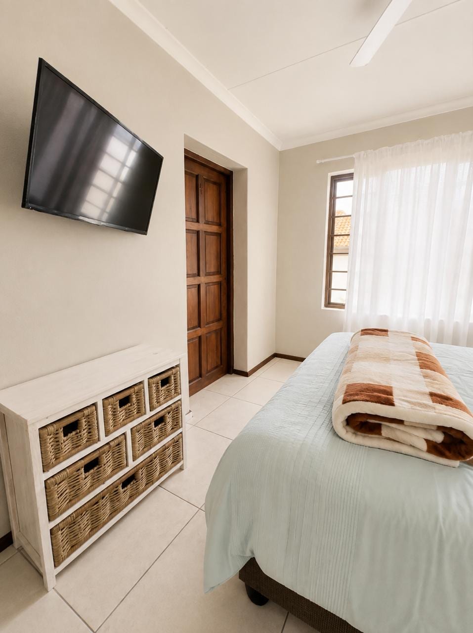 Second bedroom with a television and built-in basket storage