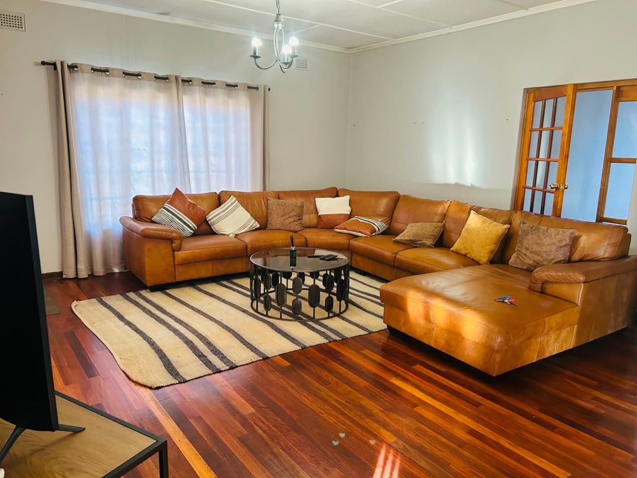 The lounge, with a leather corner suite on wooden floors