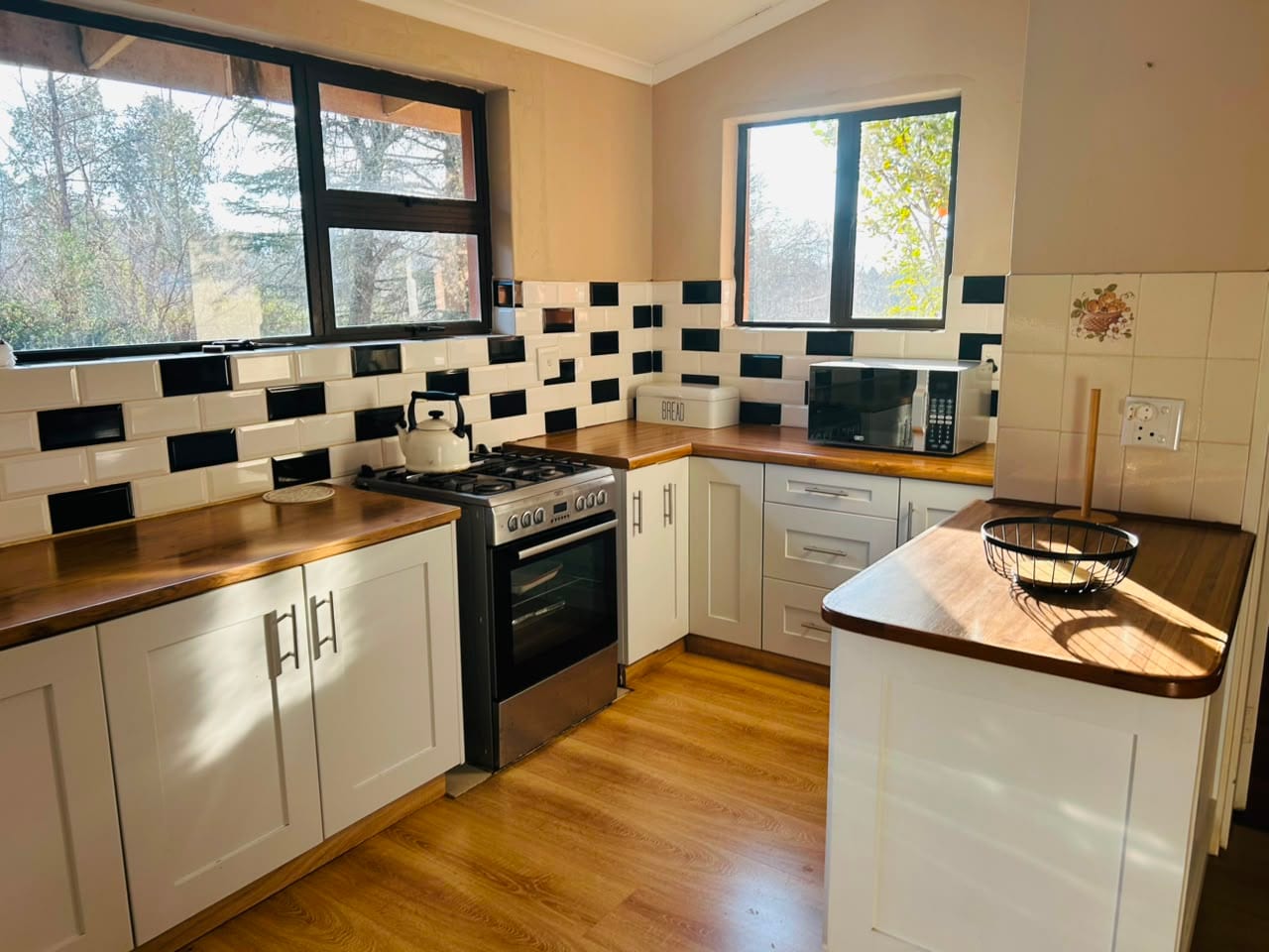 Fitted kitchen with gas hob, oven and timber counters