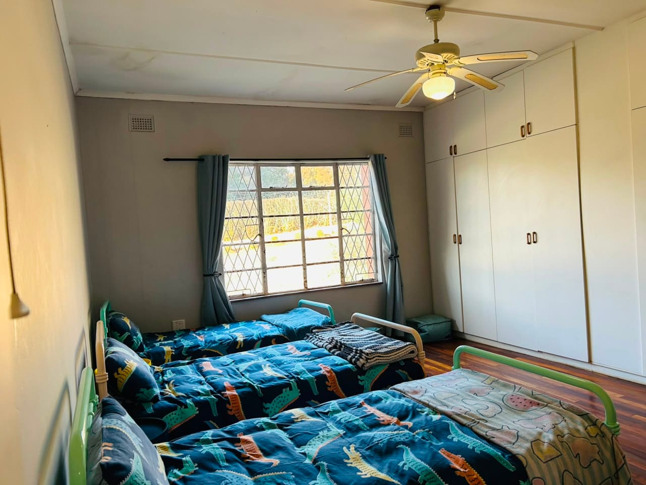 A children's room made up with three single beds